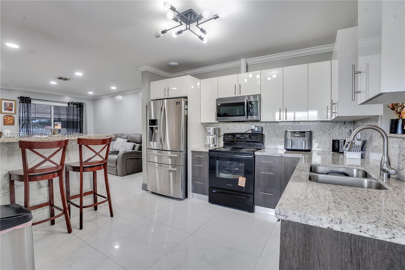 1360 Northwest 77th Street Miami, FL 33147 - Photo 8 of 41 a kitchen with stainless steel appliances granite countertop a refrigerator stove microwave and sink
