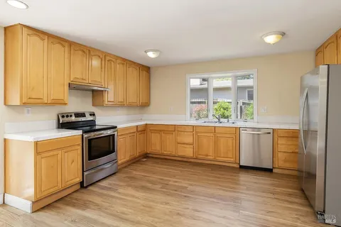 a kitchen with a refrigerator and a stove top oven
