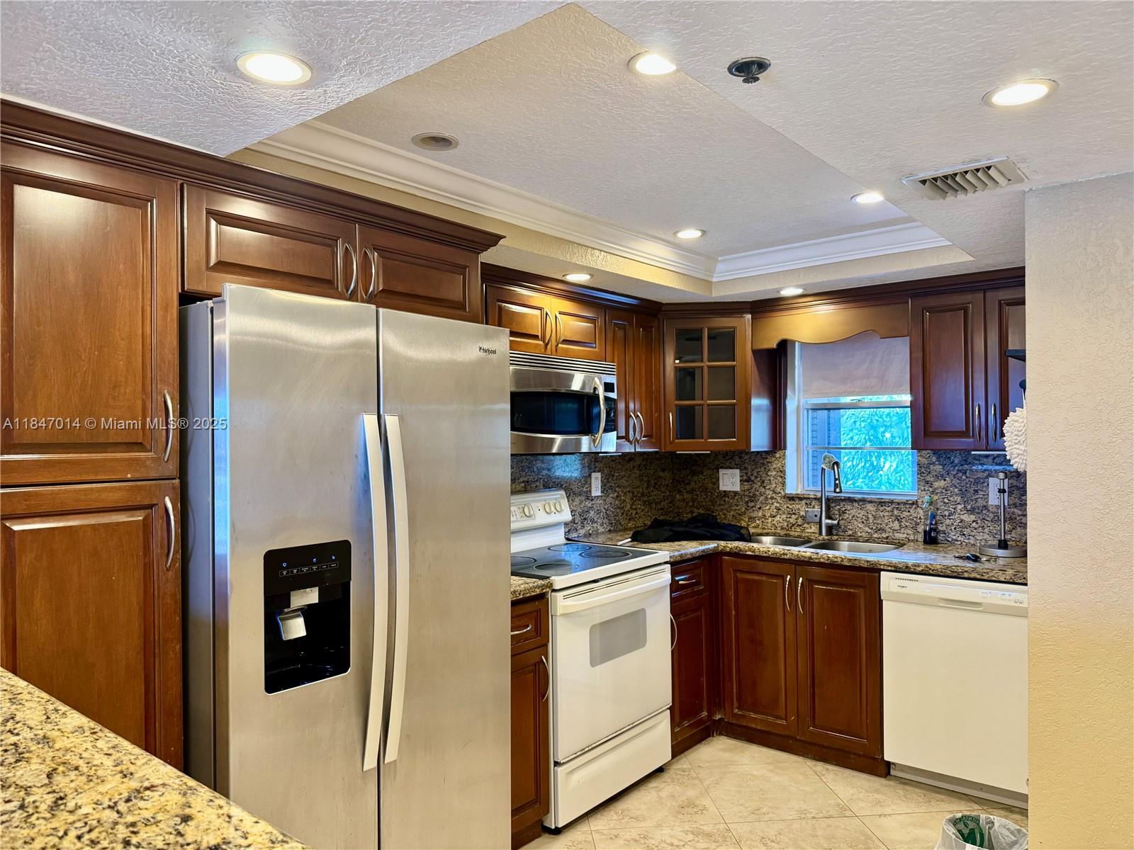 3100 West Rolling Hills Circle, Unit 407 Davie, FL 33328 - Photo 1 of 29 a kitchen with stainless steel appliances granite countertop a refrigerator a sink and a stove