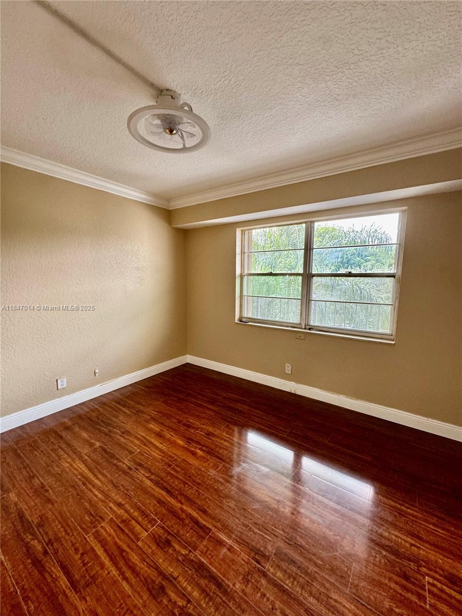 3100 West Rolling Hills Circle, Unit 407 Davie, FL 33328 - Photo 11 of 29 a view of an empty room with wooden floor and a window