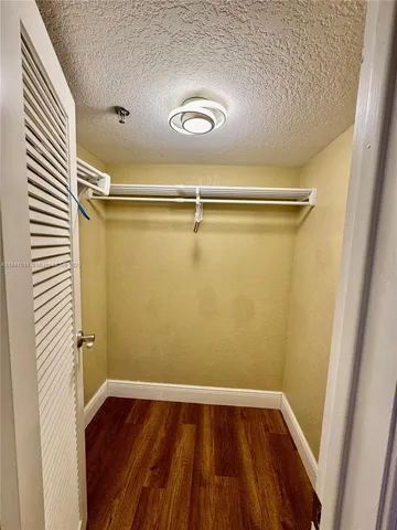 a view of closet with wooden floor