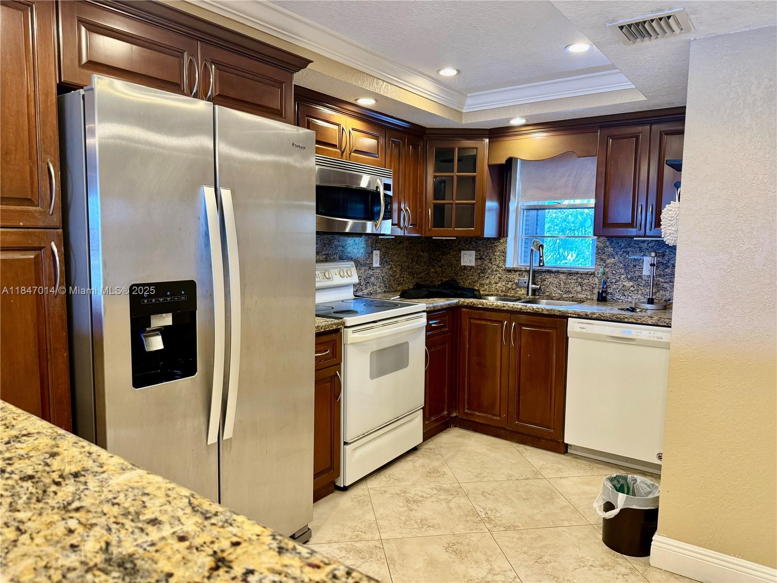 3100 West Rolling Hills Circle, Unit 407 Davie, FL 33328 - Photo 2 of 29 a kitchen with stainless steel appliances kitchen island granite countertop a refrigerator a stove and a sink with wooden floor
