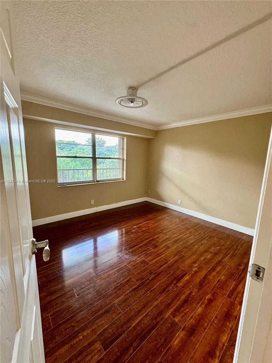 3100 West Rolling Hills Circle, Unit 407 Davie, FL 33328 - Photo 9 of 29 an empty room with wooden floor and windows