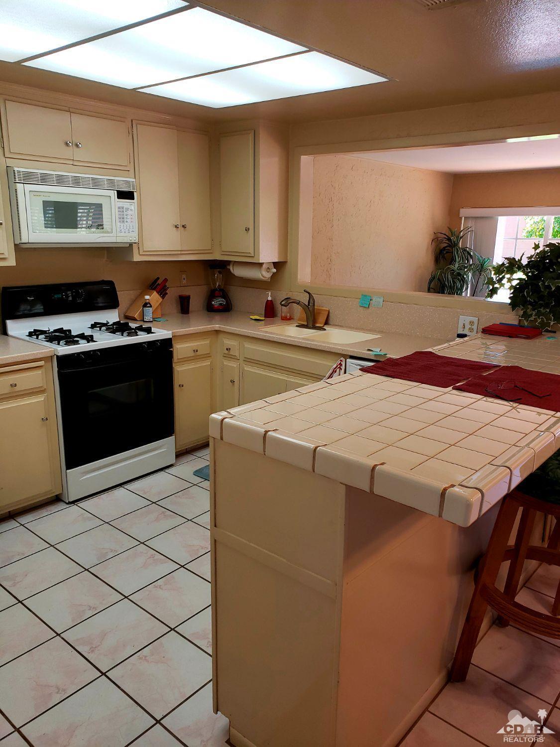36883 Palmdale Road Rancho Mirage, CA 92270 - Photo 6 of 13 a kitchen with stainless steel appliances a stove a sink and a refrigerator