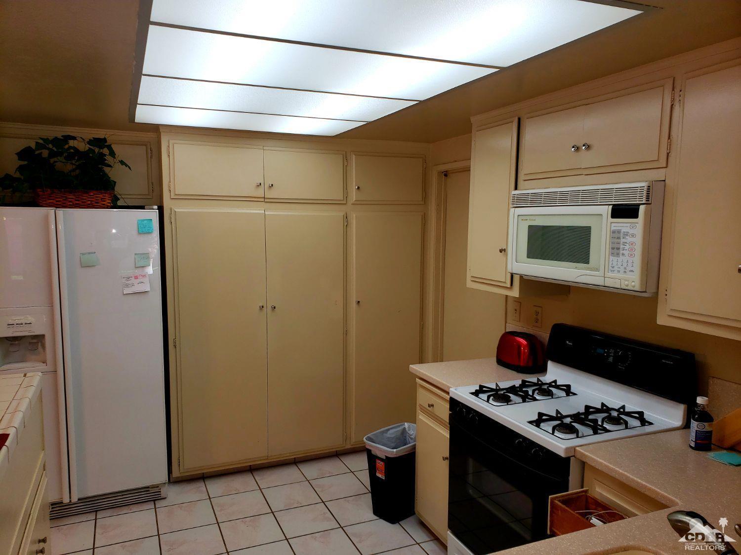 36883 Palmdale Road Rancho Mirage, CA 92270 - Photo 7 of 13 a stove top oven sitting inside of a kitchen