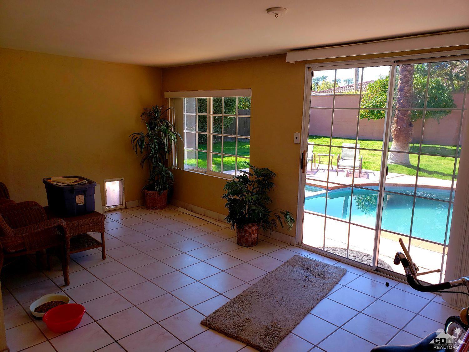 36883 Palmdale Road Rancho Mirage, CA 92270 - Photo 8 of 13 a living room with furniture and a floor to ceiling window