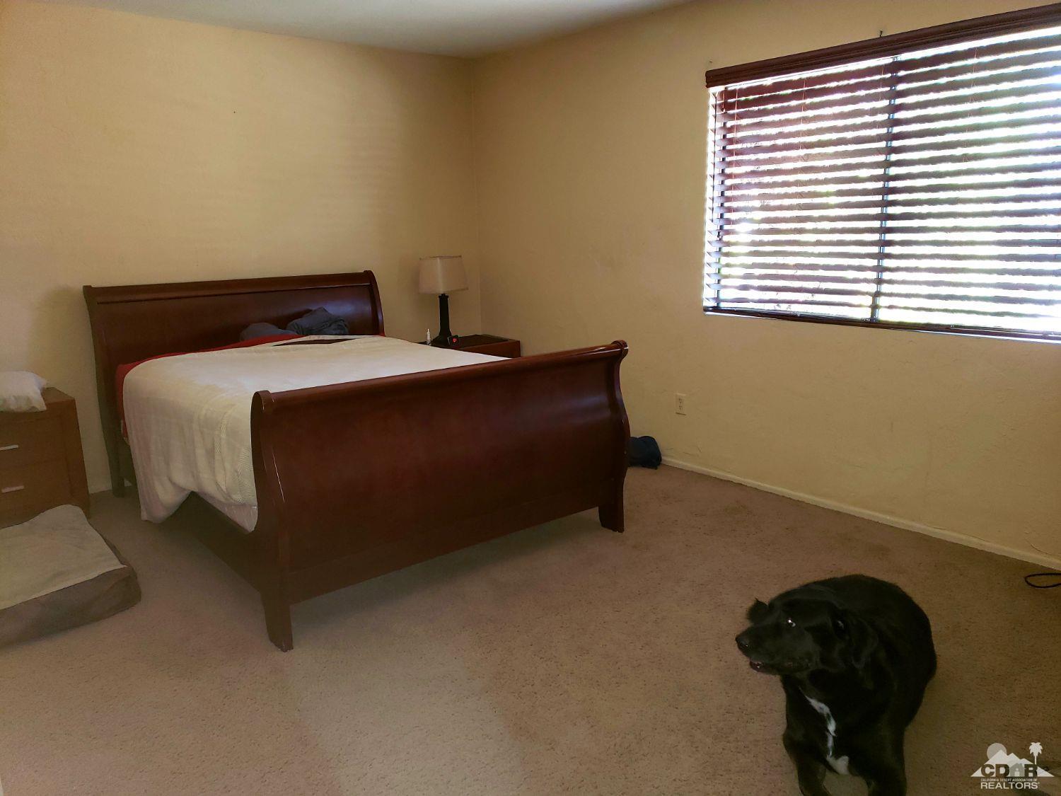 36883 Palmdale Road Rancho Mirage, CA 92270 - Photo 9 of 13 a bedroom with a bed and a window
