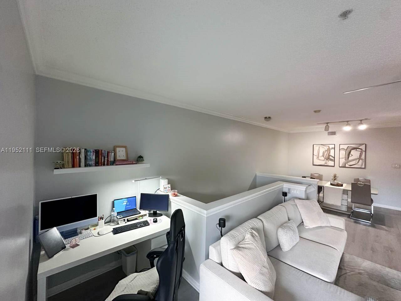 5840 West Sample Road, Unit 305 Coral Springs, FL 33067 - Photo 11 of 38 a workspace with furniture and a book shelf