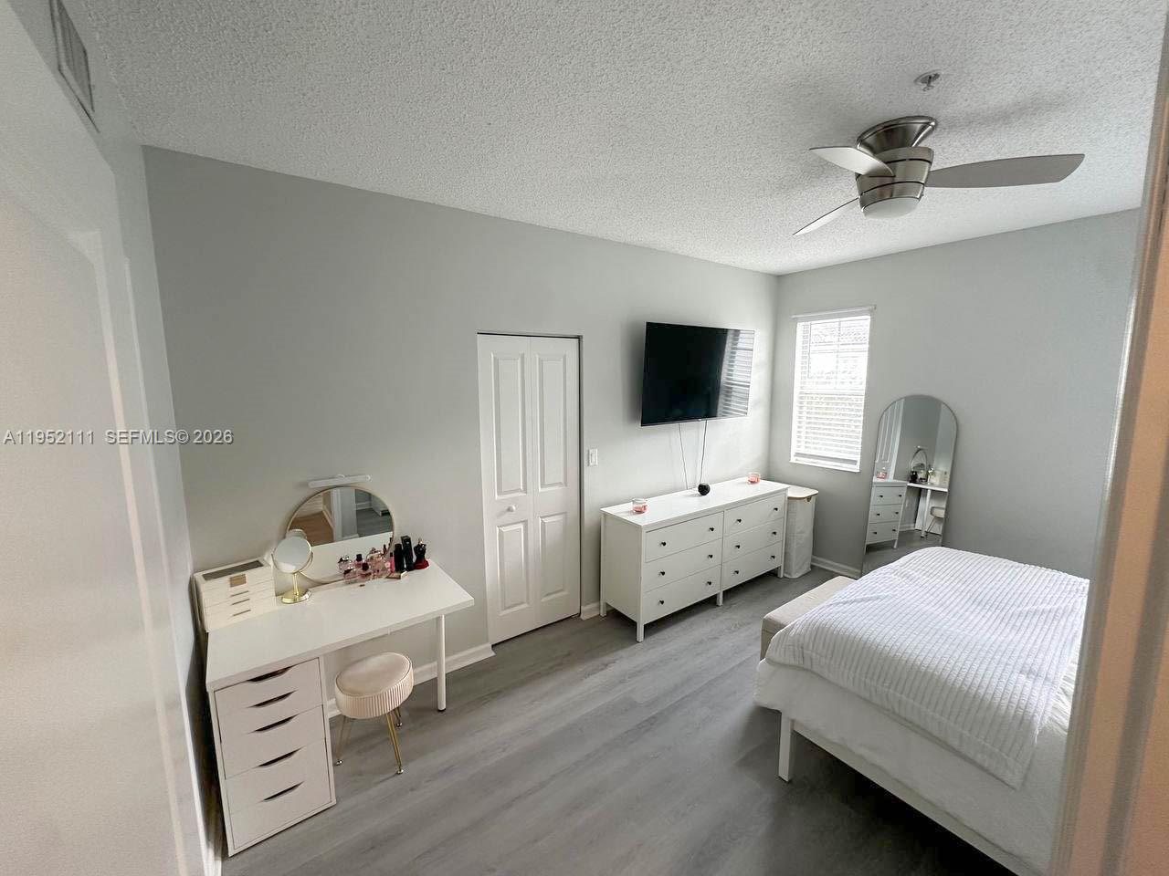 5840 West Sample Road, Unit 305 Coral Springs, FL 33067 - Photo 12 of 38 a room with a bed and a tv