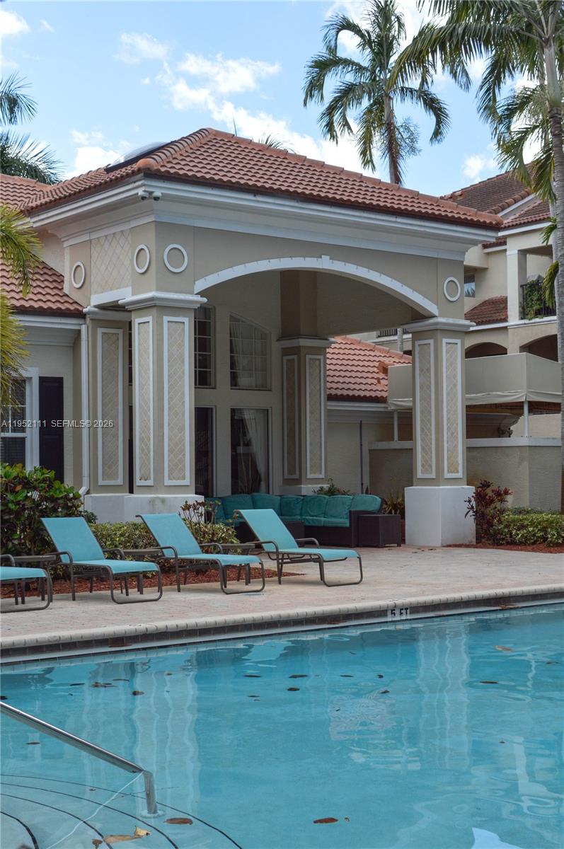 5840 West Sample Road, Unit 305 Coral Springs, FL 33067 - Photo 15 of 38 a front view of house with yard and outdoor seating