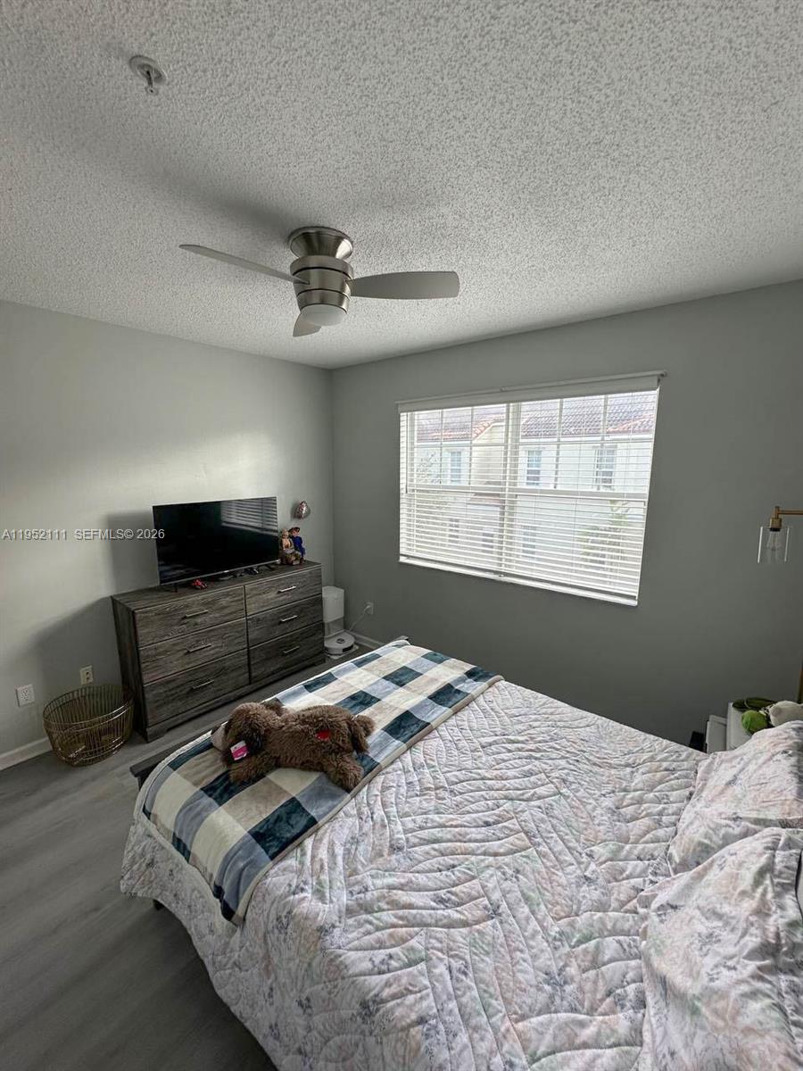 5840 West Sample Road, Unit 305 Coral Springs, FL 33067 - Photo 17 of 38 a bedroom with a bed a window and a television