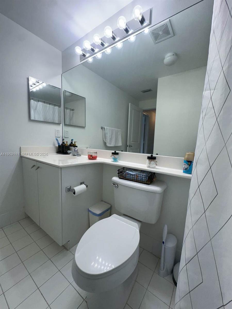 5840 West Sample Road, Unit 305 Coral Springs, FL 33067 - Photo 18 of 38 a bathroom with a sink mirror and toilet