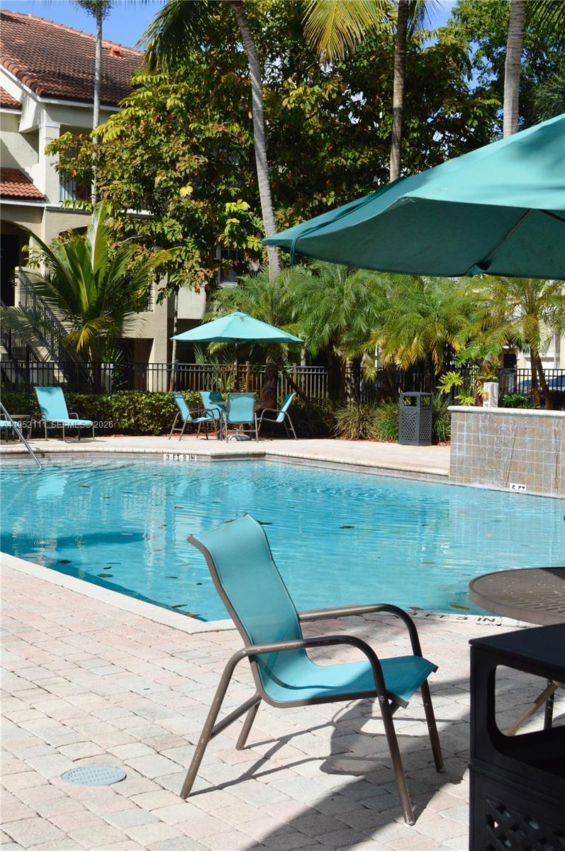 5840 West Sample Road, Unit 305 Coral Springs, FL 33067 - Photo 25 of 38 a view of a swimming pool with a patio