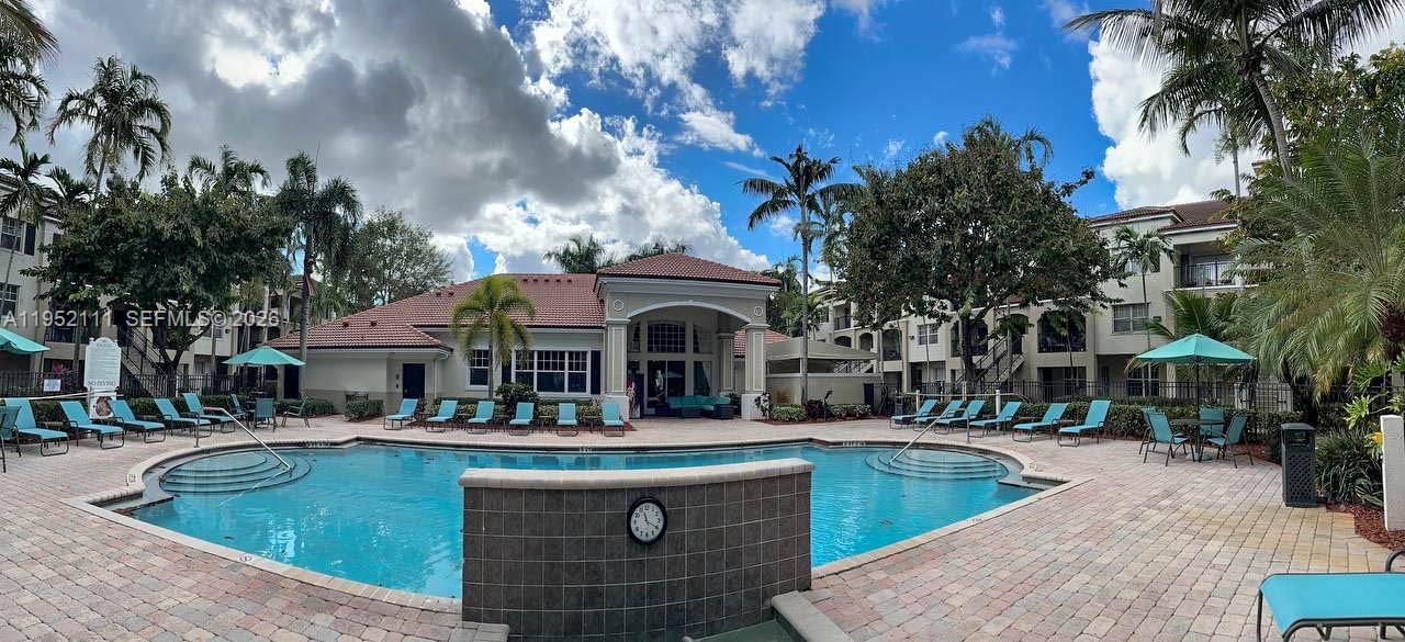 5840 West Sample Road, Unit 305 Coral Springs, FL 33067 - Photo 27 of 38 a front view of a building with swimming pool and outdoor seating