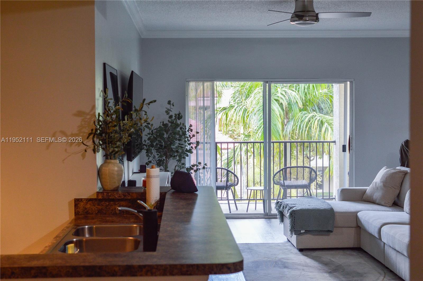 5840 West Sample Road, Unit 305 Coral Springs, FL 33067 - Photo 3 of 38 a living room with furniture and a potted plant