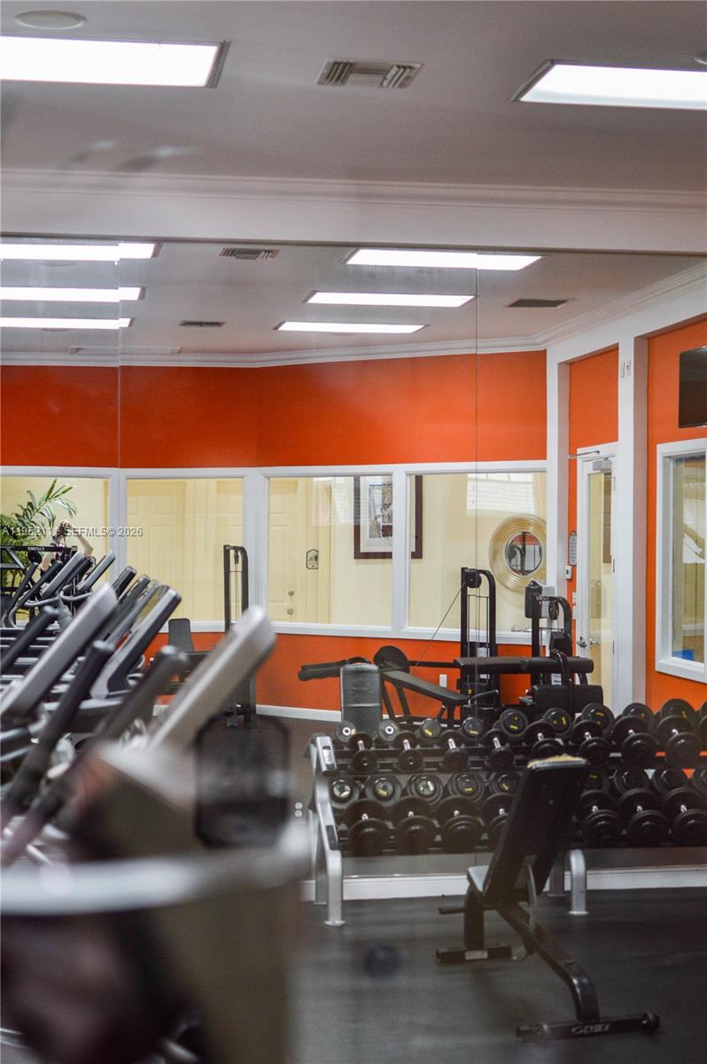 5840 West Sample Road, Unit 305 Coral Springs, FL 33067 - Photo 32 of 38 a room with lots of equipment and large windows