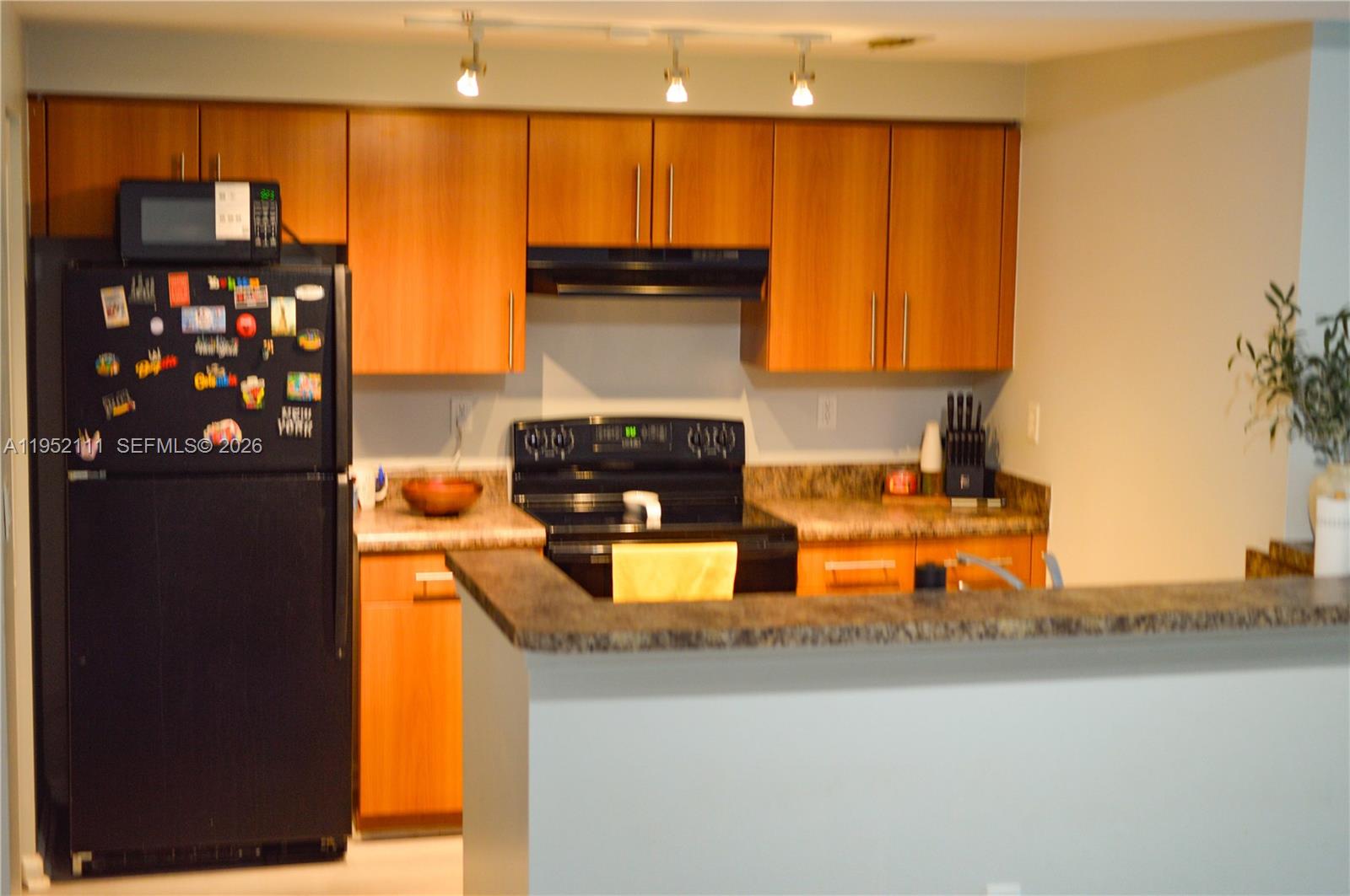 5840 West Sample Road, Unit 305 Coral Springs, FL 33067 - Photo 6 of 38 a kitchen with granite countertop a refrigerator and a stove top oven
