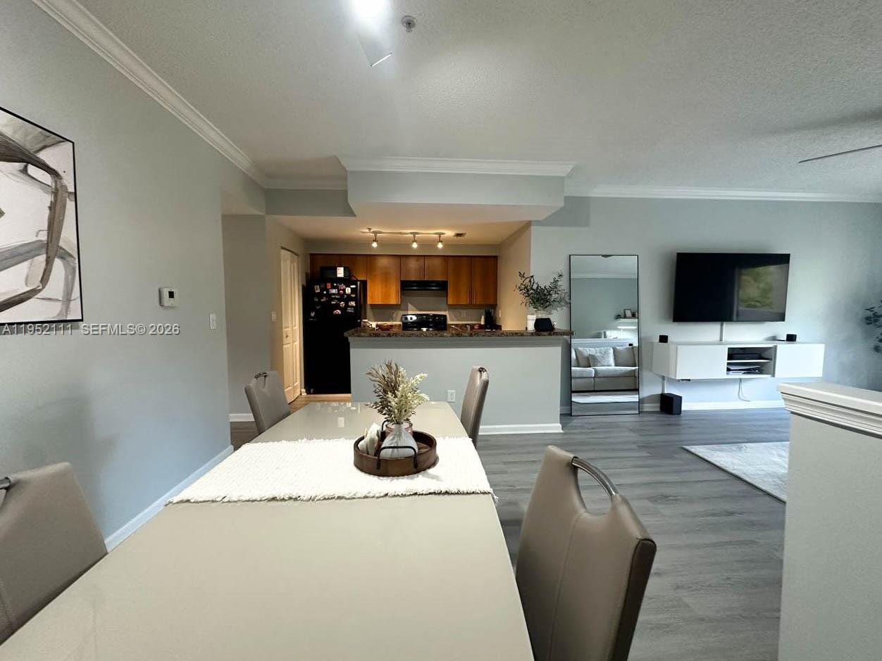 5840 West Sample Road, Unit 305 Coral Springs, FL 33067 - Photo 7 of 38 a living room with furniture a flat screen tv and kitchen view