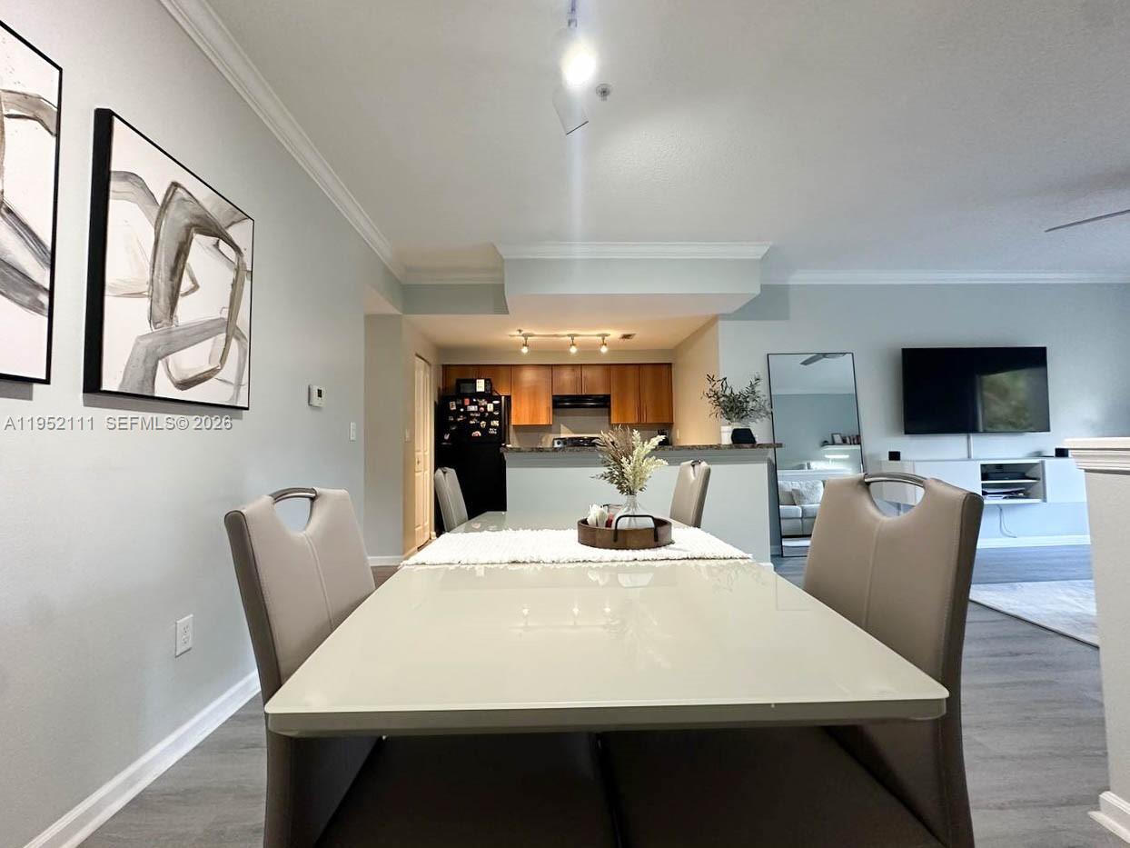 5840 West Sample Road, Unit 305 Coral Springs, FL 33067 - Photo 9 of 38 a view of a dining room with furniture and wooden floor