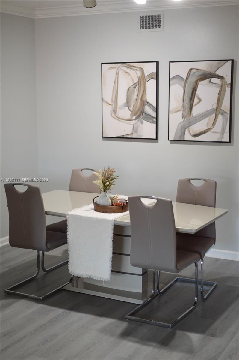 5840 West Sample Road, Unit 305 Coral Springs, FL 33067 - Photo 10 of 38 a view of a dining room with furniture and wooden floor