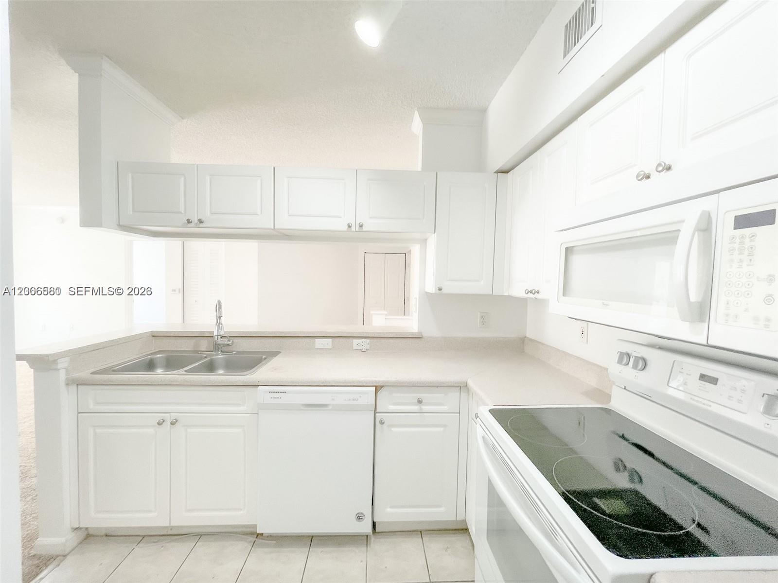 17150 North Bay Road, Unit 2602 Sunny Isles Beach, FL 33160 - Photo 9 of 27 a kitchen with granite countertop a sink stove and cabinets