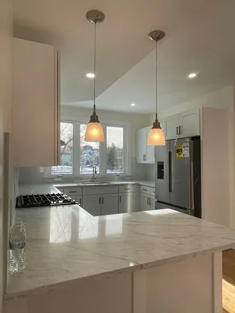 a kitchen with a refrigerator a sink and a wooden floor