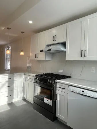 a kitchen with cabinets appliances and a wooden floor