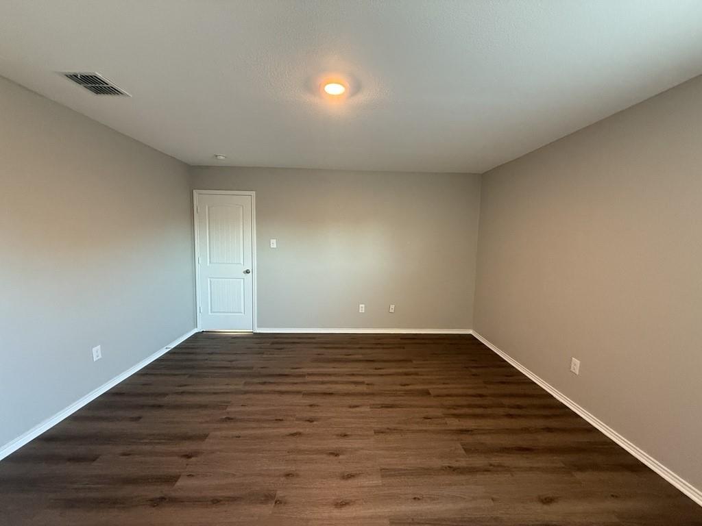 413 Everglades Street Princeton, TX 75407 - Photo 12 of 39 a view of an empty room with wooden floor
