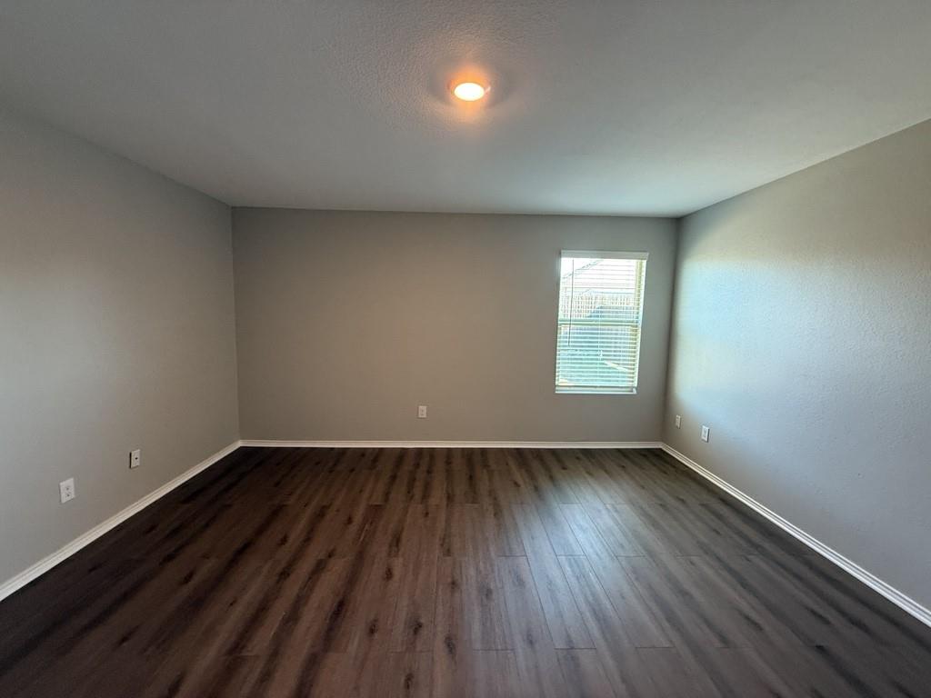413 Everglades Street Princeton, TX 75407 - Photo 13 of 39 an empty room with wooden floor and windows
