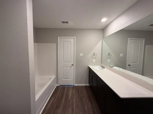 a bathroom with a sink a mirror and a bathtub