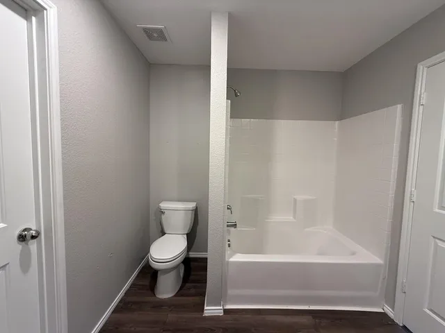 a bathroom with a toilet and a bathtub