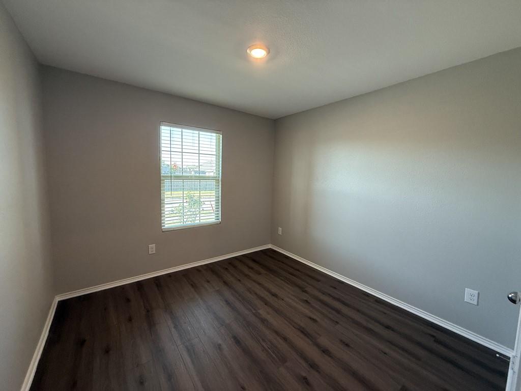 413 Everglades Street Princeton, TX 75407 - Photo 22 of 39 a view of an empty room with wooden floor and a window