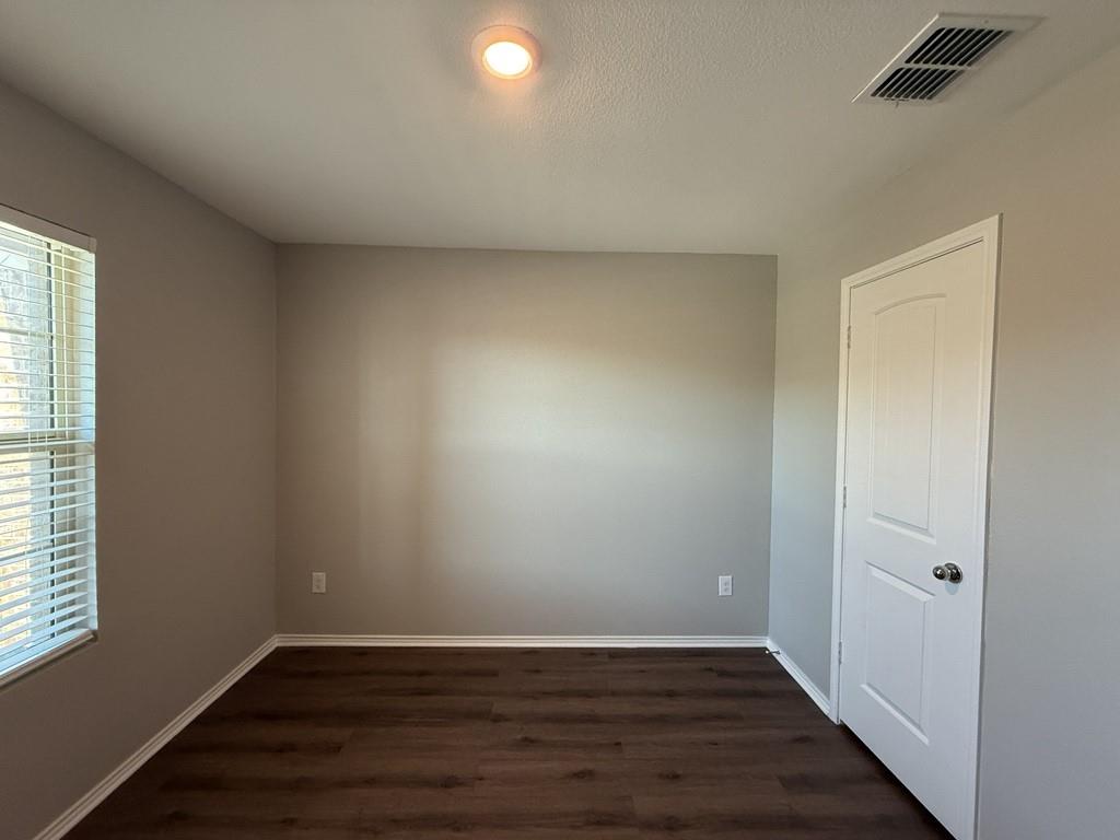 413 Everglades Street Princeton, TX 75407 - Photo 23 of 39 an empty room with wooden floor and windows