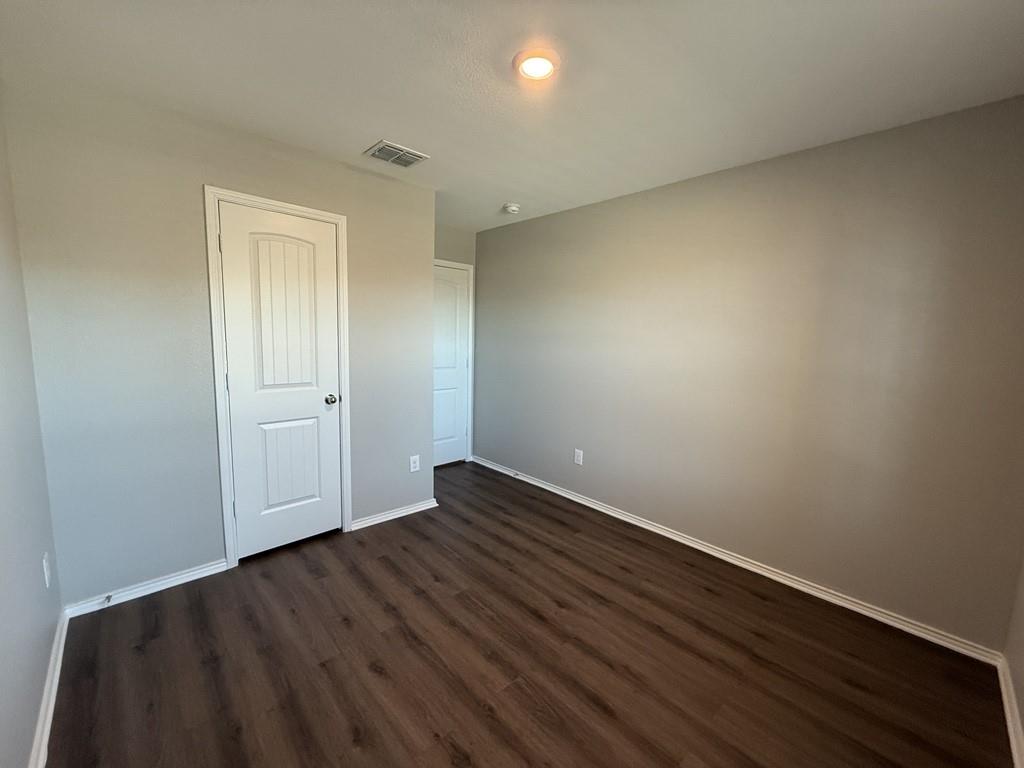 413 Everglades Street Princeton, TX 75407 - Photo 25 of 39 an empty room with wooden floor and windows