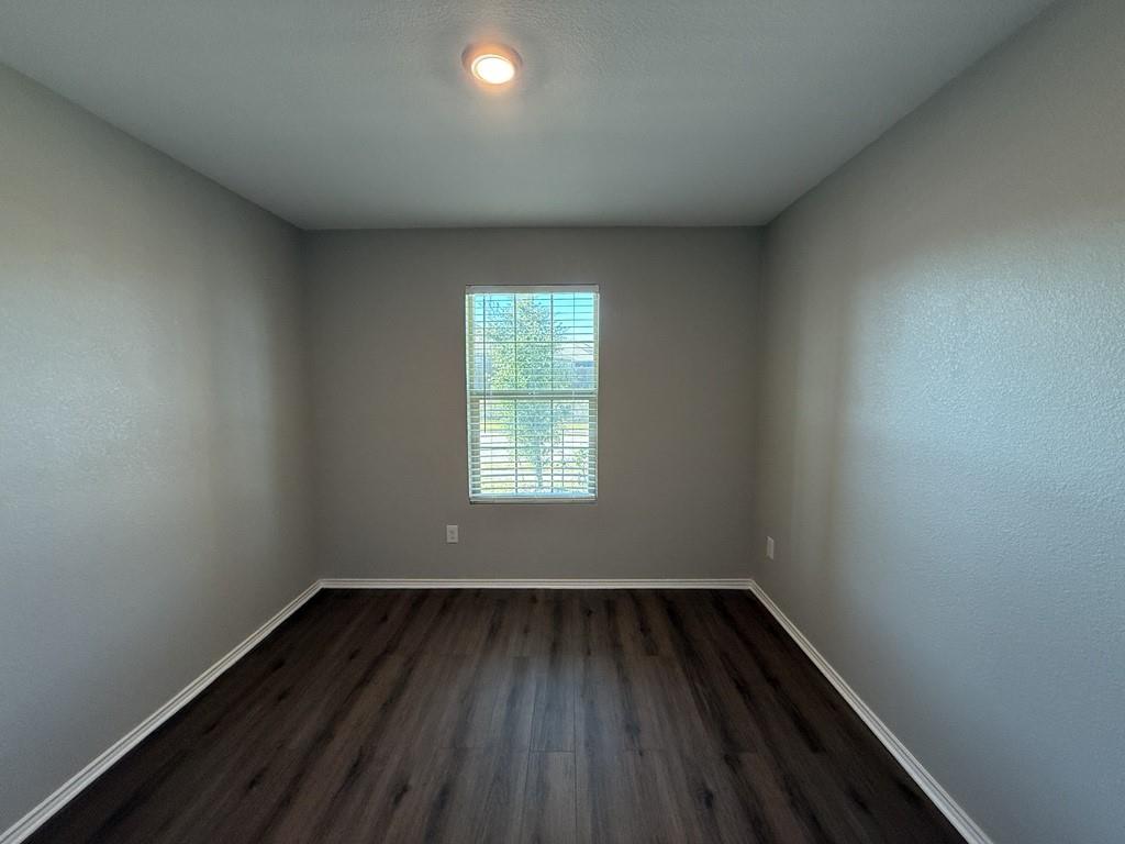 413 Everglades Street Princeton, TX 75407 - Photo 26 of 39 an empty room with wooden floor and windows