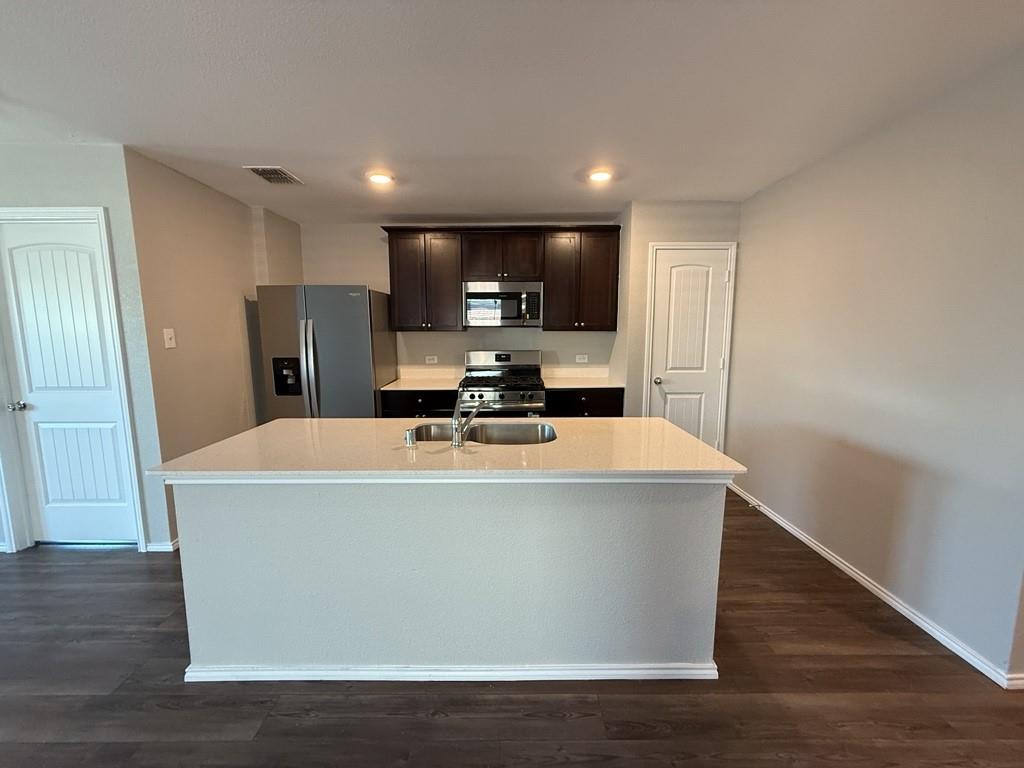 413 Everglades Street Princeton, TX 75407 - Photo 3 of 39 a view of a refrigerator in kitchen and wooden floor