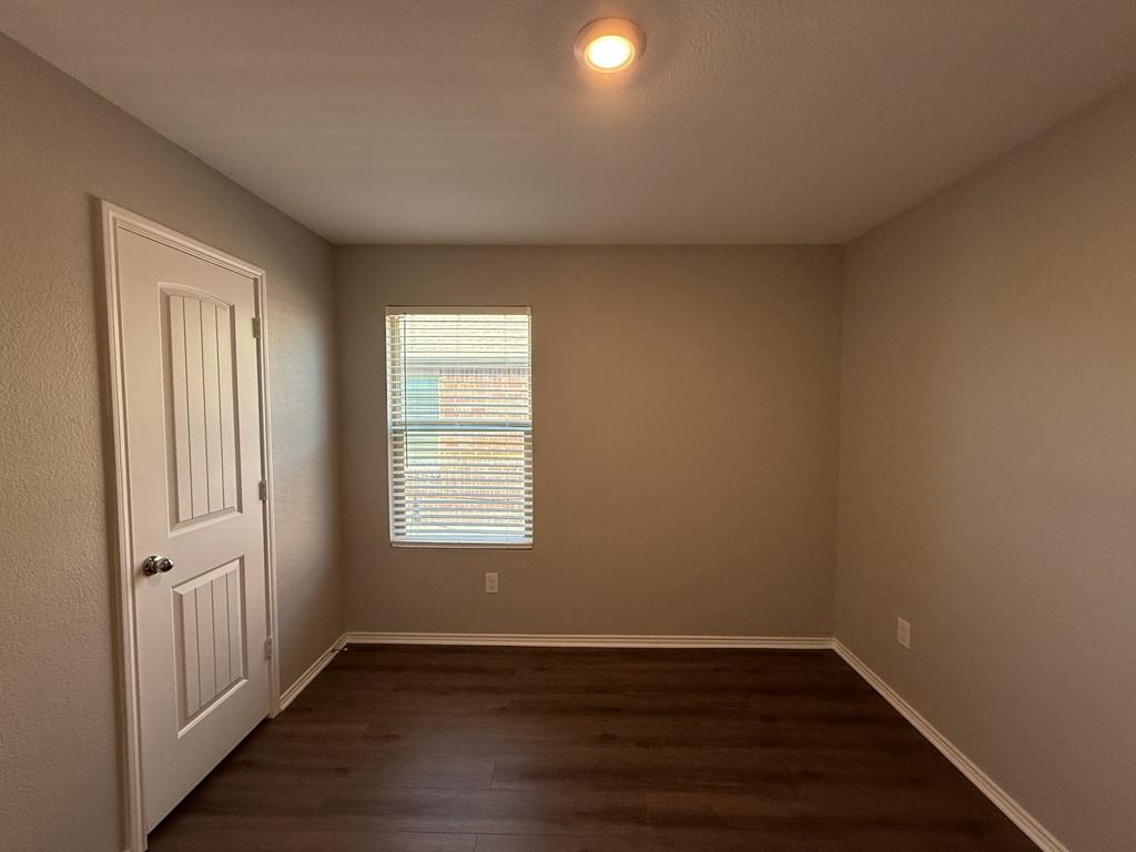 413 Everglades Street Princeton, TX 75407 - Photo 33 of 39 an empty room with wooden floor and windows