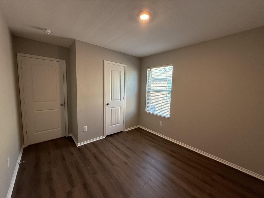 413 Everglades Street Princeton, TX 75407 - Photo 34 of 39 an empty room with wooden floor and windows