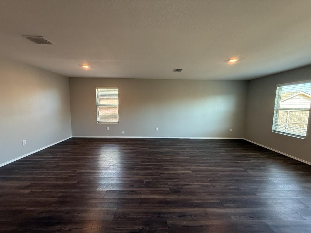 413 Everglades Street Princeton, TX 75407 - Photo 6 of 39 an empty room with wooden floor and windows