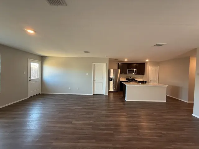 a view of kitchen with kitchen island stainless steel appliances refrigerator stove microwave and cabinets