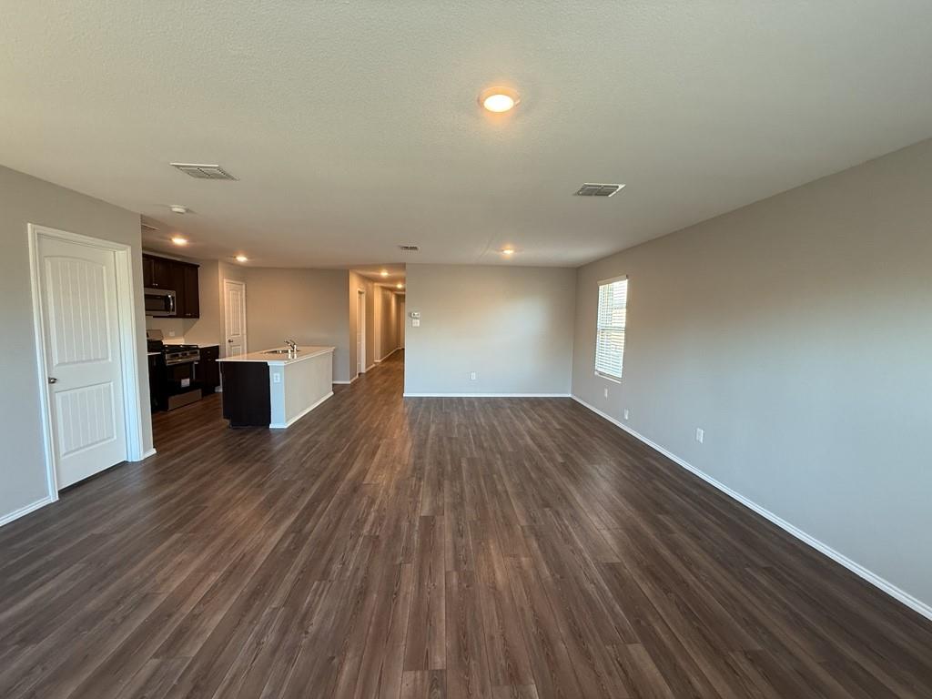 413 Everglades Street Princeton, TX 75407 - Photo 9 of 39 a view of empty room with wooden floor