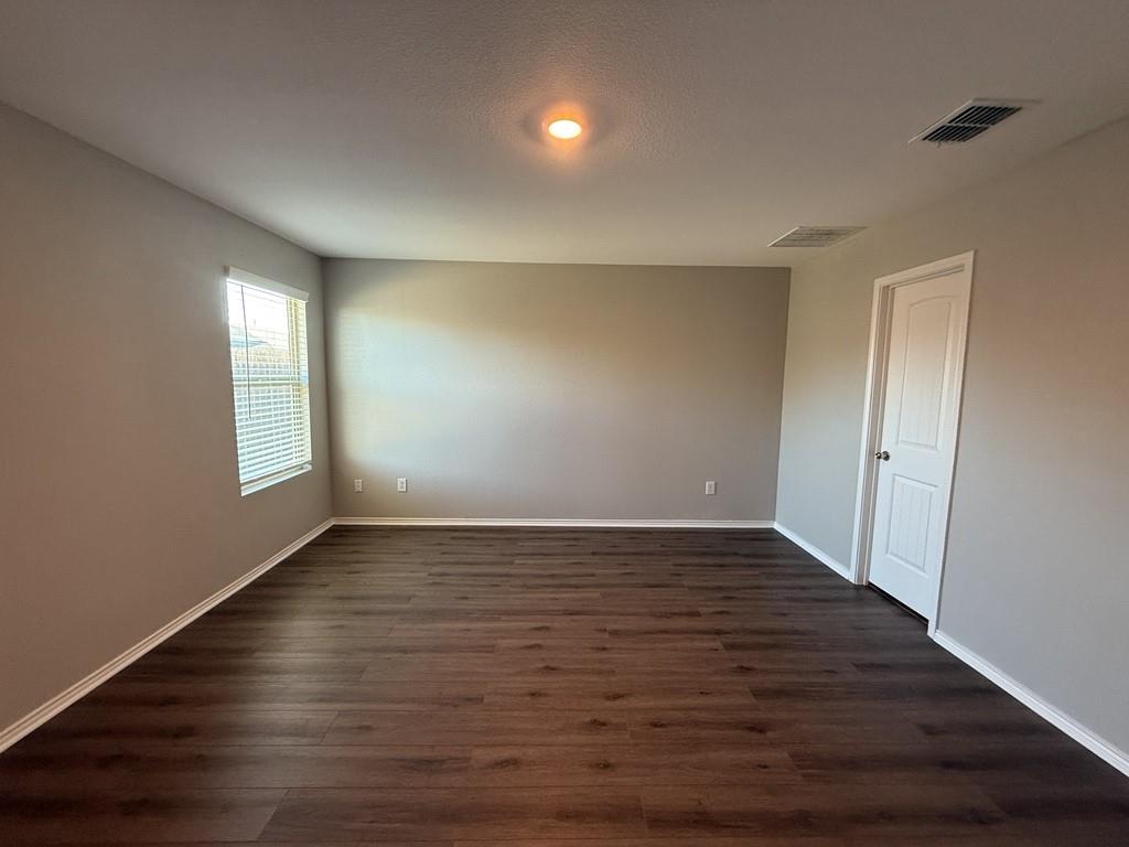 413 Everglades Street Princeton, TX 75407 - Photo 10 of 39 a view of an empty room with wooden floor and a window