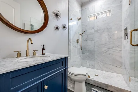 a bathroom with a granite countertop sink a mirror and a shower