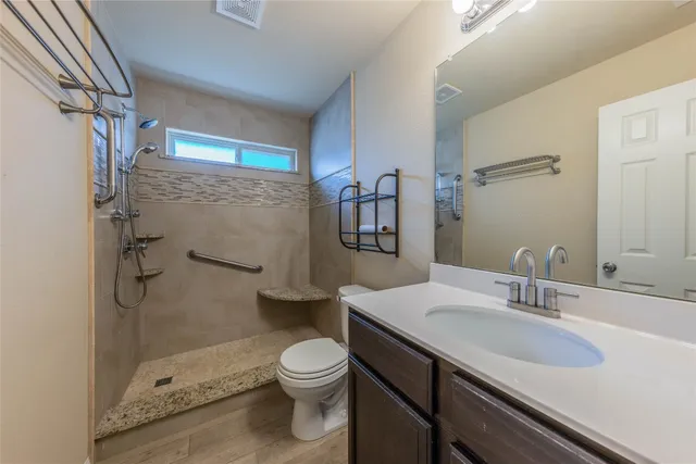 a bathroom with a sink a toilet and shower