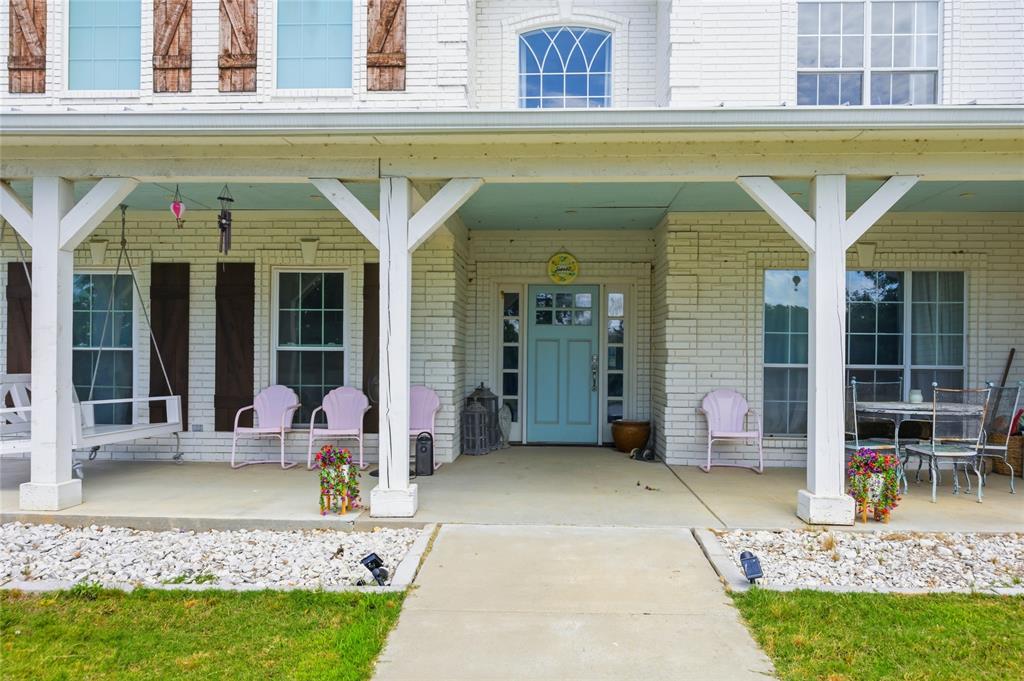 1073 Gordonville Road Gordonville, TX 76245 - Photo 7 of 38 Greeting you as you walk to the home, a big covered porch with chairs calls to come in, sit as spell, and enjoy the serene nature of the land aroudn you,