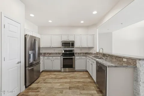 a kitchen with stainless steel appliances granite countertop a stove and a sink