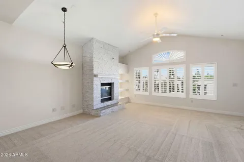 an empty room with a kitchen and a ceiling fan