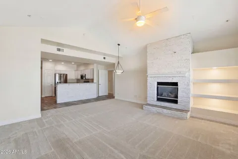 an empty room with windows and fireplace