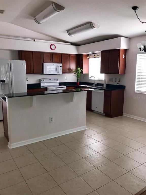 7019 Belt Link Loop Wesley Chapel, FL 33545 - Photo 3 of 14 a kitchen with stainless steel appliances granite countertop a sink and a stove
