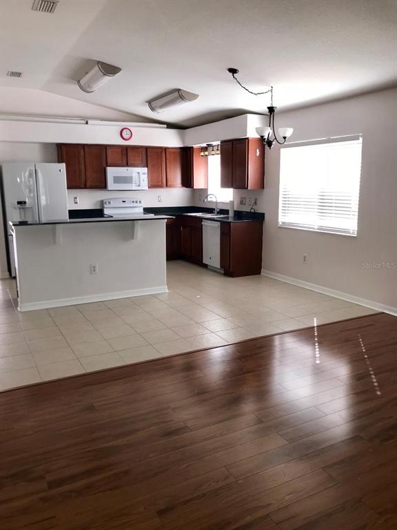 7019 Belt Link Loop Wesley Chapel, FL 33545 - Photo 4 of 14 a large kitchen with stainless steel appliances wooden floors and view living room